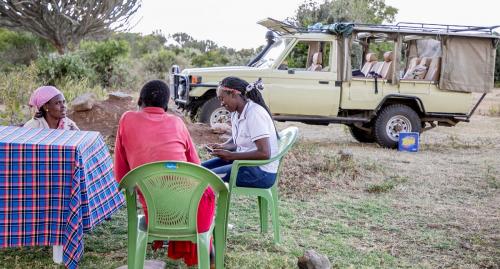 Mugie's nurse, Jedidah talks to community members  during an outreach clinic